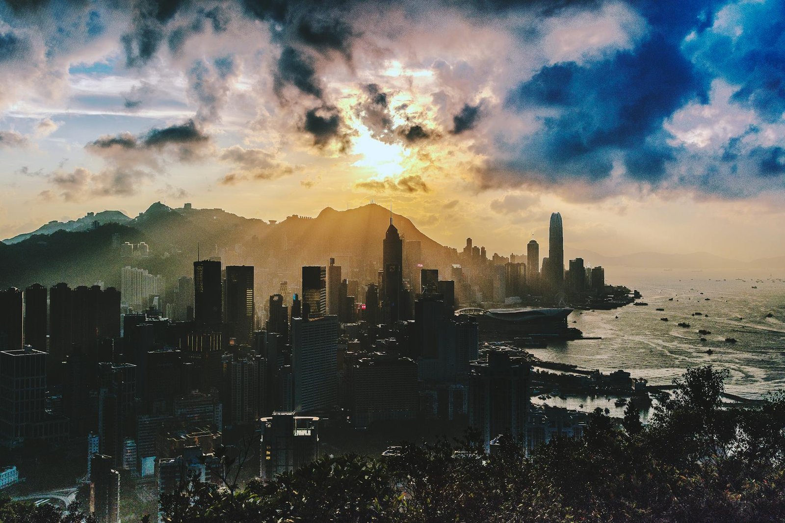Dramatic sunset over the skyline of Hong Kong Island with vibrant colors and sea view.
