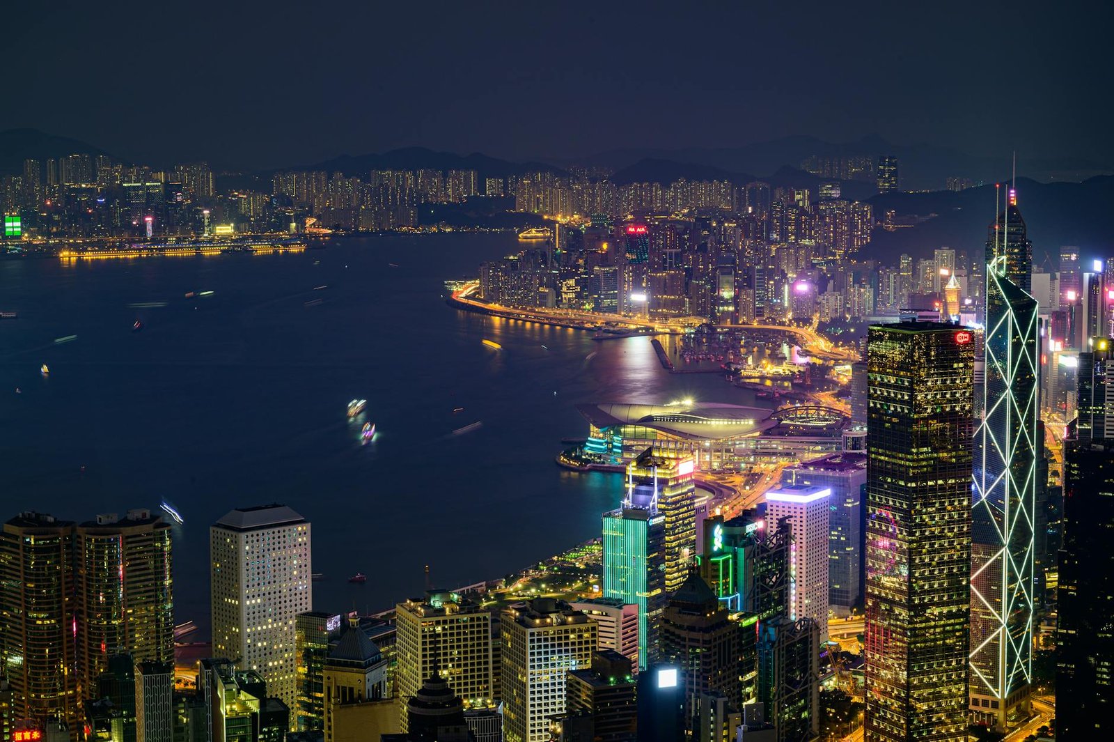 Stunning nighttime view of Hong Kong Island with illuminated skyscrapers and vibrant cityscape across Victoria Harbor.