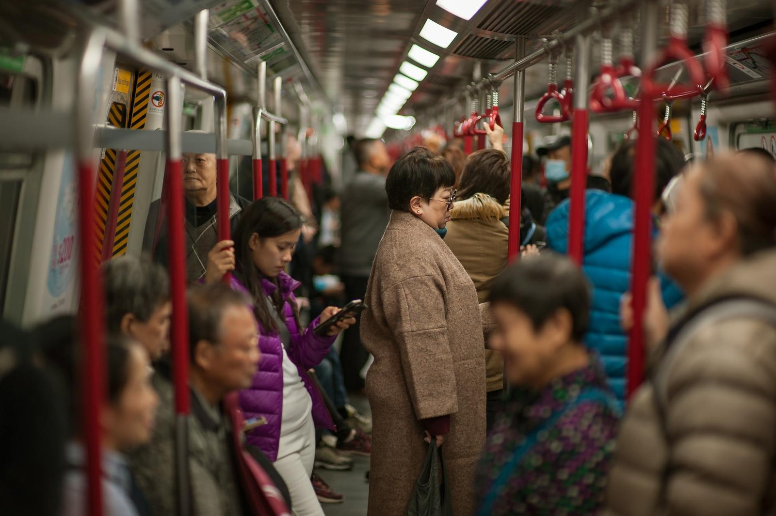 Passengers crowded inside a Hong Kong Island subway carriage during daytime travel.