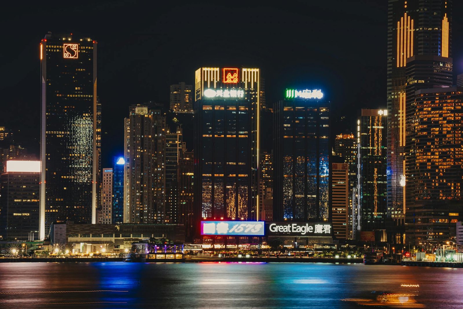 Stunning night view of Hong Kong's illuminated skyline with reflections on a calm harbor.