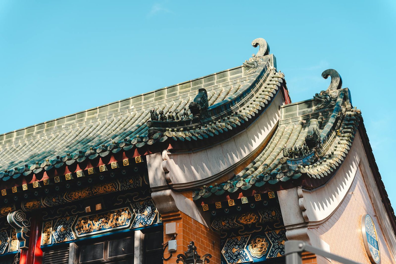 Detailed view of a traditional Chinese temple roof with intricate carvings and tiles in Hong Kong.