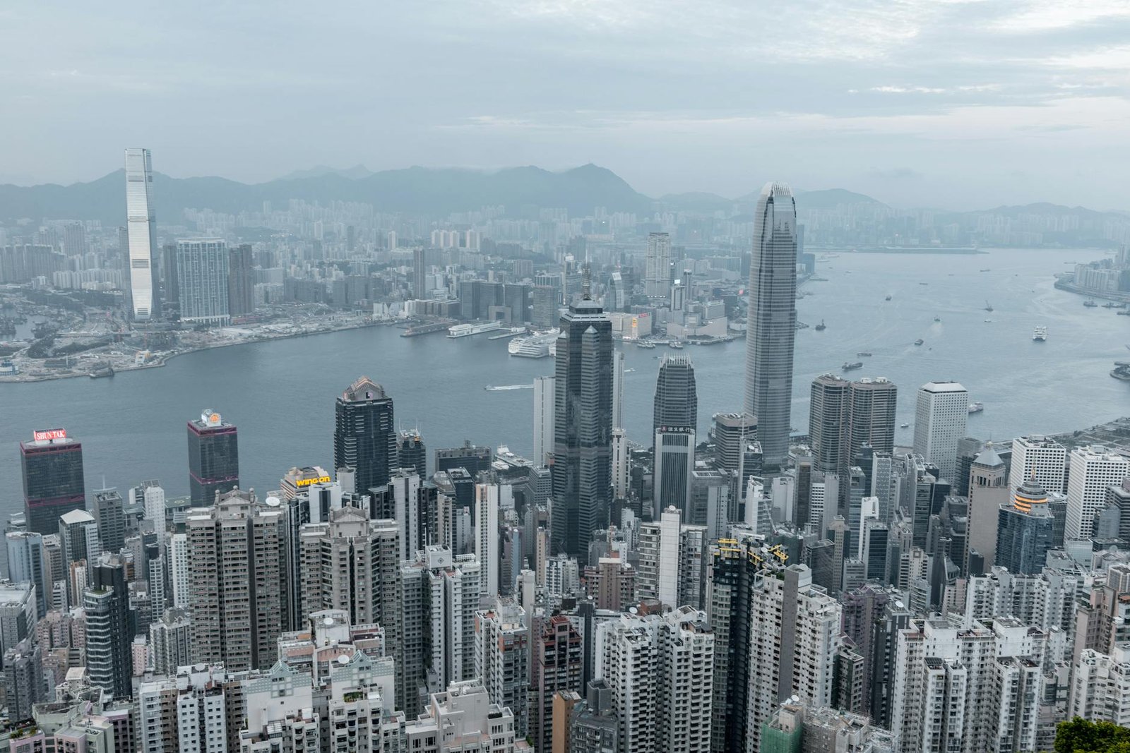 Vast cityscape of Hong Kong with modern skyscrapers and a river backdrop.
