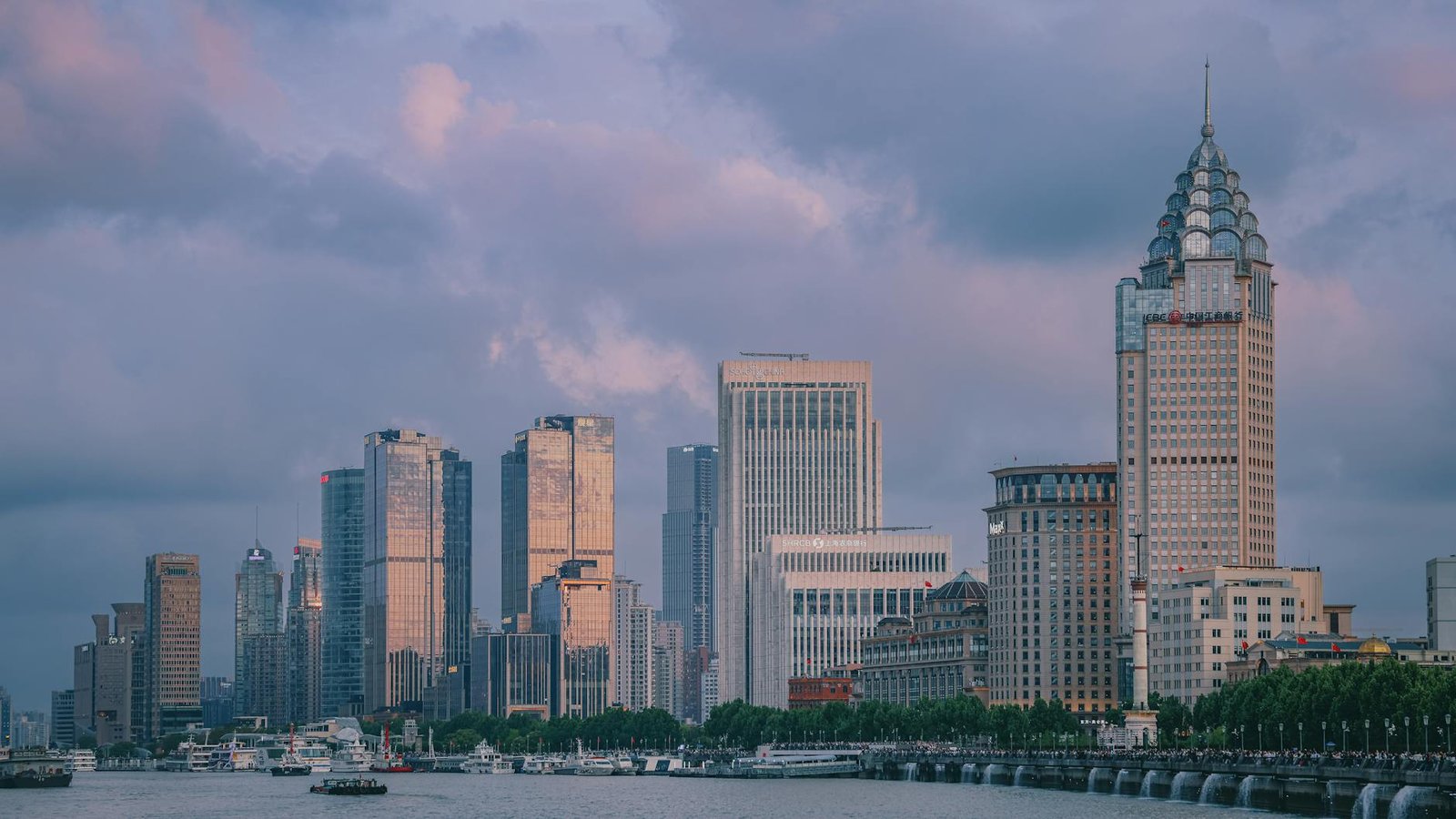 View of Shanghai's modern skyline at twilight with tall skyscrapers and vibrant clouds.