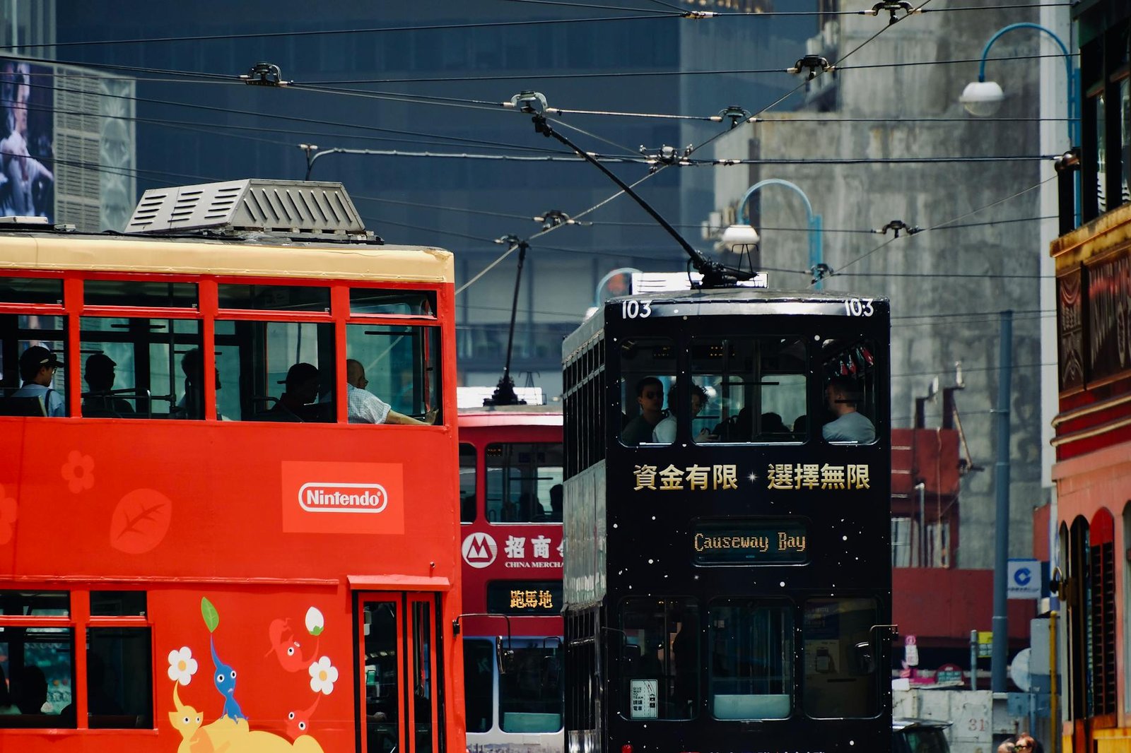 Vibrant trams pass each other on a busy street in Causeway Bay, Hong Kong Island.