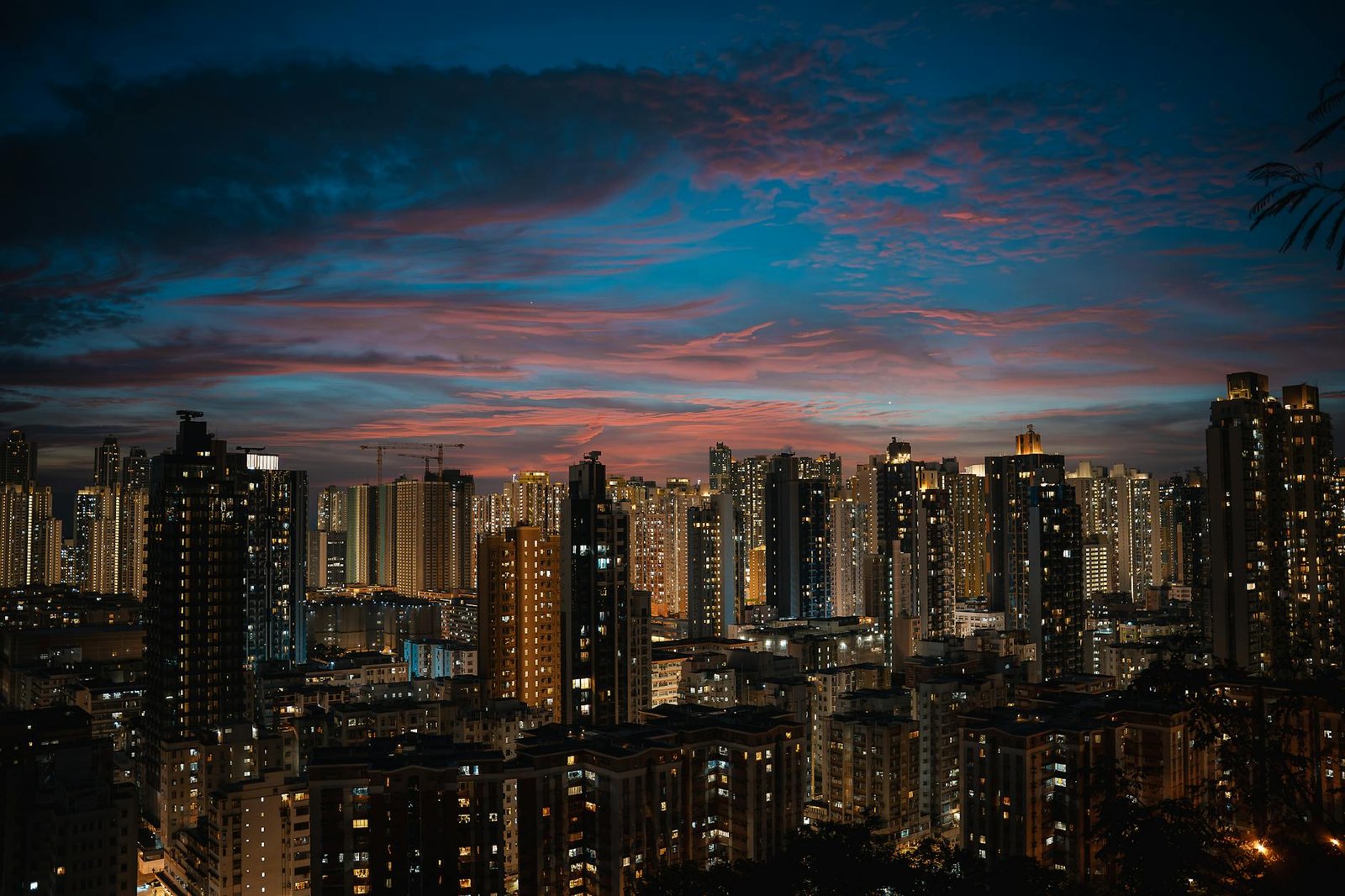 Stunning view of Hong Kong's cityscape at twilight, featuring illuminated skyscrapers and dramatic evening clouds.